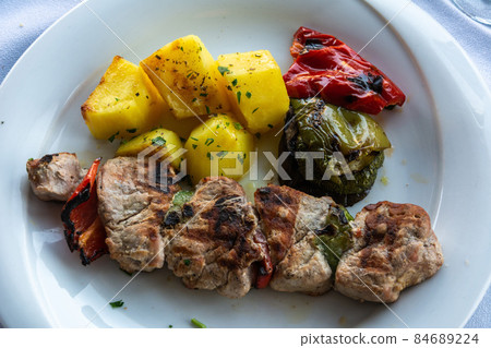 Greek souvlaki kebap with grilled tomatoes. Greek souvlaki kebap with grilled tomatoes. 84689224