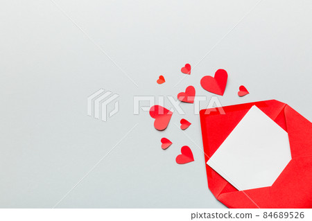 Red paper envelope with empty white card and heart on colored background. top view valentines day concept Red paper envelope with empty white card and heart on colored background. top view valentines day concept 84689526