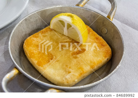 Pan with fried halloumi cheese and lemon 84689992