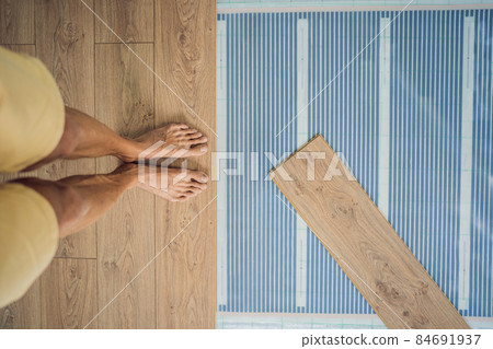 Wooden floor, laminate on a warm film floor. Comfort in home. Warm floor concept. Heating in the house and apartment 84691937