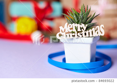 The inscription Merry Christmas on a cactus against the background of New Year gift boxes The inscription Merry Christmas on a cactus against the background of New Year gift boxes 84693022