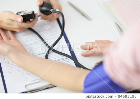 Doctor measuring patients blood pressure with tonometer tool in office 84693195