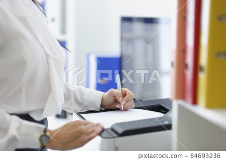 Female secretary or office worker print papers on printer machine Female secretary or office worker print papers on printer machine 84693236