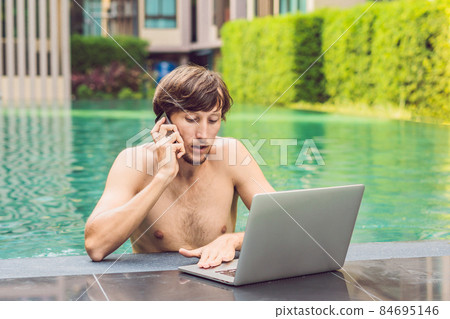 Young freelancer working on vacation next to the swimming pool 84695146