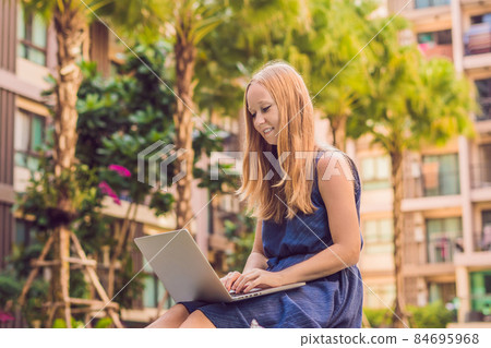Young female freelancer sitting near the pool with her laptop. Busy at holidays. Distant work concept. Copy space for your text Young female freelancer sitting near the pool with her laptop. Busy at holidays. Distant work concept. Copy space for your text 84695968