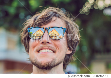 Male tourist looking at Thai temple in Phuket Town Wat Mongkolnimit Male tourist looking at Thai temple in Phuket Town Wat Mongkolnimit 84696465