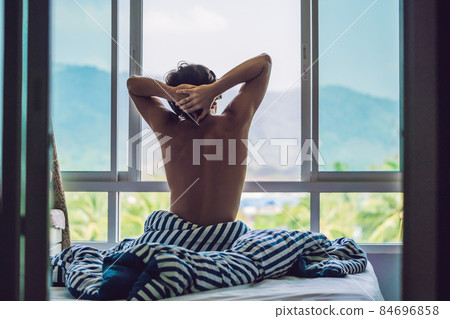 Man wake up and stretching in morning with mountain view Man wake up and stretching in morning with mountain view 84696858