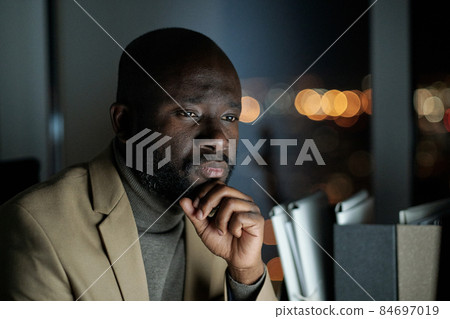 Serious man in formalwear sitting in front of computer monitor 84697019
