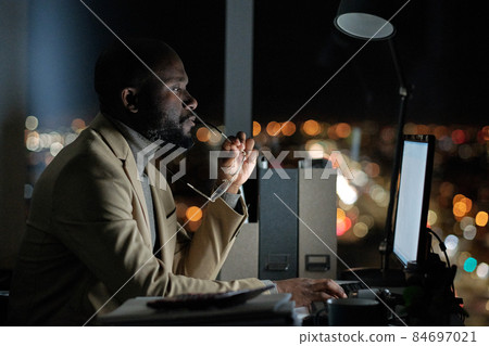 Serious businessman in suit looking at computer screen 84697021