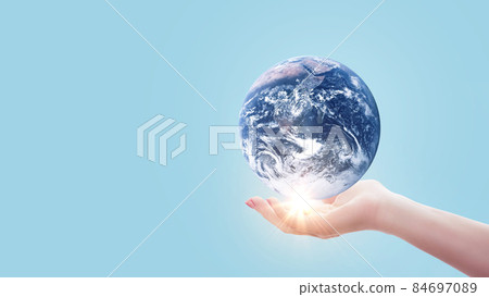 Hand holds blue planet Earth with sunset light on pastel blue color. Save Earth concept. Environment creative idea Hand holds blue planet Earth with sunset light on pastel blue color. Save Earth concept. Environment creative idea 84697089