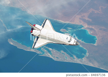 Spacecraft shuttle flies over the beautiful overhead view of the planet Earth with the sea and islands. Space rocket in the sky fly over the mainland explores space and planets. Aerial Shot 84697136