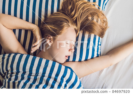Beautiful young woman lying down in bed and sleeping. Do not get enough sleep concept Beautiful young woman lying down in bed and sleeping. Do not get enough sleep concept 84697920