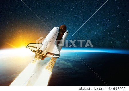 Space rocket flies in outer space with blue planet Earth and amazing sunset. Spaceship on a mission and is flying in cosmos with stars. Space travel concept and spacecraft lift off  84698031