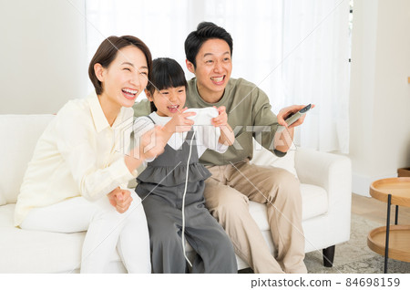 享受比賽的三個父母和孩子的家庭 享受比賽的三個父母和孩子的家庭 84698159