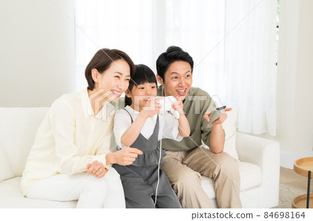 A family of three parents and children enjoying the game 84698164