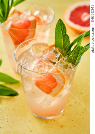 Pink cocktail with ice and sage, selective focus. Pink cocktail with ice and sage, selective focus. 84698342