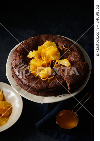 Chocolate cake with orange zest and citrus sauce. Brownie with orange. 84698352