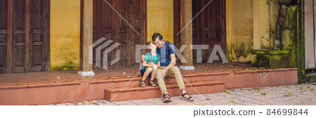 BANNER, LONG FORMAT Dad and son travelers on background of Hoi An ancient town, Vietnam. Vietnam opens to tourists again after quarantine Coronovirus COVID 19 84699844