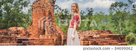 BANNER, LONG FORMAT Woman tourist in Temple ruin of the My Son complex, Vietnam. Vietnam opens to tourists again after quarantine Coronovirus COVID 19 84699862