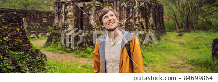 BANNER, LONG FORMAT Man tourist in Temple ruin of the My Son complex, Vietnam. Vietnam opens to tourists again after quarantine Coronovirus COVID 19 84699864