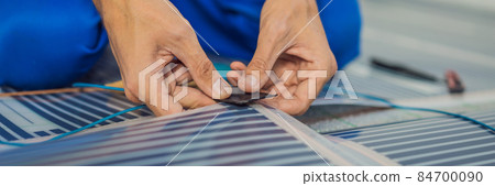 Master installs film warm floor in the room. Floor heating installation BANNER, LONG FORMAT 84700090