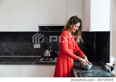 woman housewife cooks fresh vegetables for cooking 84700984