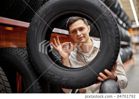 male customer taking new tires in the supermarket. male customer taking new tires in the supermarket. 84701792