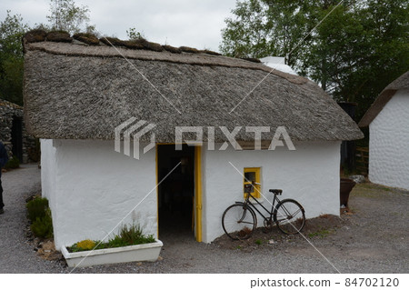 County Kerry, Republic of Ireland, August 15th 2019: A traditional 19th Century thatched Cottage at the Kerry Bog Village Museum in County Kerry, Republic of Ireland. County Kerry, Republic of Ireland, August 15th 2019: A traditional 19th Century thatched Cottage at the Kerry Bog Village Museum in County Kerry, Republic of Ireland. 84702120