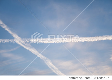 Twilight sky with effect of light pastel blue colors and trail of plane. Colorful sunset of soft clouds. Twilight sky with effect of light pastel blue colors and trail of plane. Colorful sunset of soft clouds. 84703526
