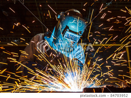 worker with protective mask welding metal 84703952