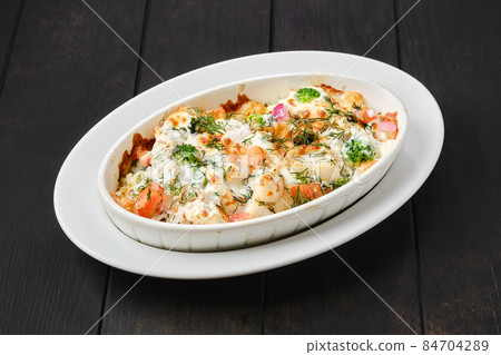 Potato and ham baked in oven with cheese and vegetables Potato and ham baked in oven with cheese and vegetables 84704289
