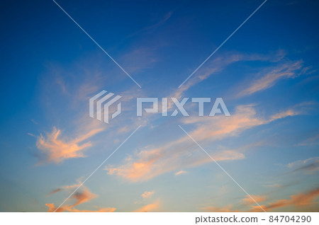 Pink and light orange clouds in the evening sky. 84704290