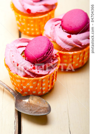 pink berry cream cupcake with macaroon on top 84704366