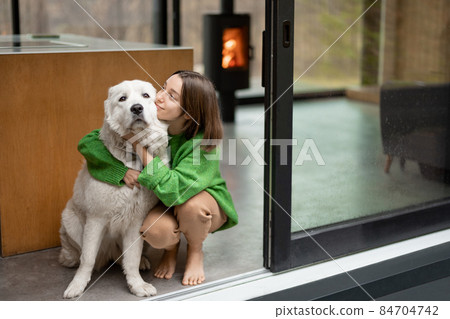 Young woman with her dog at modern house on nature 84704742