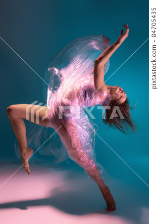 Solo performance. Beautiful flexible contemp dancer dancing with fabric isolated on gradient blue white background in neon light 84705435