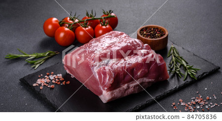 Raw pork steak on a cutting board with herbs and spices Raw pork steak on a cutting board with herbs and spices 84705836