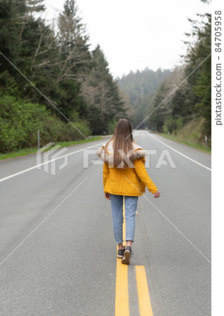 future concept. highway road among forest with walking girl. future concept. highway road among forest with walking girl. 84705958