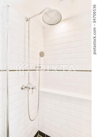 Contemporary bathroom with bathtub and glass shower cabin with light light tile and white ceiling Contemporary bathroom with bathtub and glass shower cabin with light light tile and white ceiling 84706536