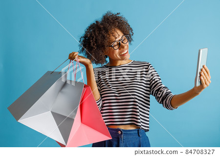 Joyful woman with shopping bags making selfie 84708327