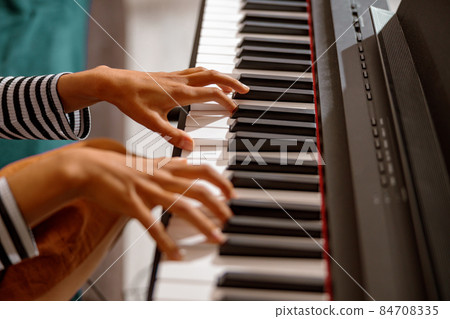 Young woman hands playing on synthesizer keyboard Young woman hands playing on synthesizer keyboard 84708335