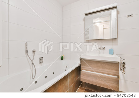 Stylish interior design of small bathroom with white walls and shelves and with large mirror near sink 84708548