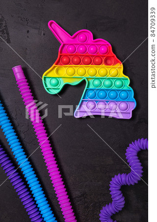 Bright antistress pop it children toys on black concrete Bright antistress pop it children toys on black concrete 84709339