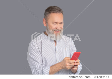 Mature man with a smartphone in hands 84709454