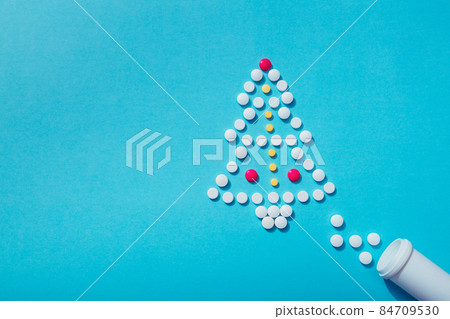 Creative Christmas tree made of pills on a blue background Holiday greeting card with space for text 84709530