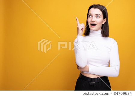 The girl in the studio on a yellow background raised her thumb up with an idea of emotion. The girl in the studio on a yellow background raised her thumb up with an idea of emotion. 84709684