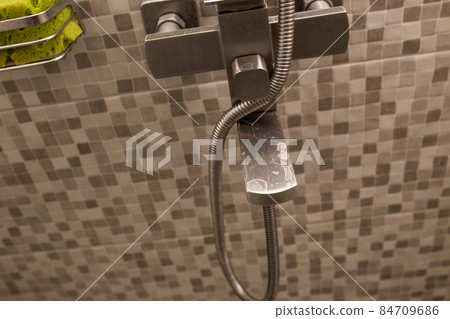 Water tap in the bathroom close-up. Hard water. Plaque on the tap from dirty water. Water tap in the bathroom close-up. Hard water. Plaque on the tap from dirty water. 84709686