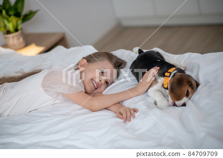 Happy female child spending time with her pet dog Happy female child spending time with her pet dog 84709709