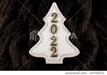 Christmas and 2022 New Year concept. Christmas tree decoration is made from wool on the brown fur background. 84709832
