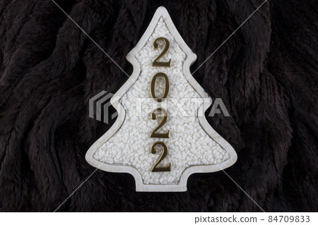 Christmas and 2022 New Year concept. Christmas tree decoration is made from wool on the brown fur background. 84709833