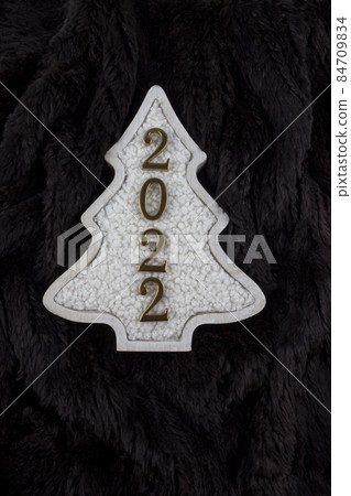 Christmas and 2022 New Year concept. Christmas tree decoration is made from wool on the brown fur background. 84709834